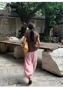 Vue arrière détaillée d'une femme portant un haut à manches volantées et un pantalon rose