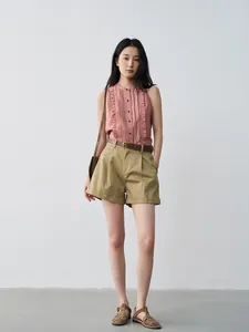Casual women's pleated khaki shorts styled with a pink ruffled sleeveless shirt