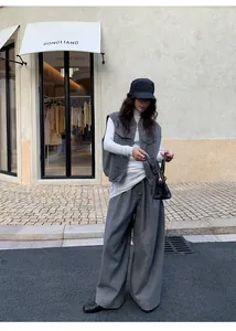 Street style εμφάνιση με λευκό ζιβάγκο, γκρι γιλέκο και φαρδύ παντελόνι