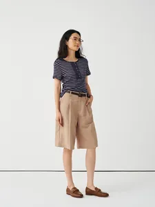 Asian female model wearing a navy striped T-shirt and khaki linen shorts in studio