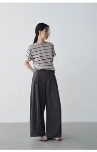 Vista detallada de camiseta de lino a rayas de verano con pantalones anchos grises