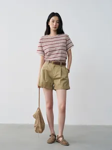 Modelo asiática con camiseta de lino a rayas, mangas de encaje bordado y pantalones cortos.