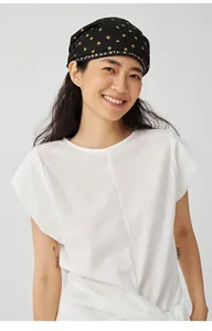 Modell trägt minimalistisches weißes Strick-T-Shirt mit unregelmäßigem Bindedesign
