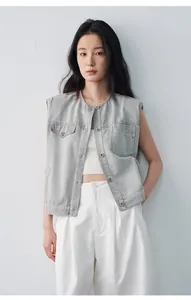 Dettaglio di un gilet di jeans grigio ampio con scollo rotondo e bottoni