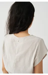 Detailansicht des hinteren Knopfes an einem beigen minimalistischen Strick-Fly-Sleeve-T-Shirt.