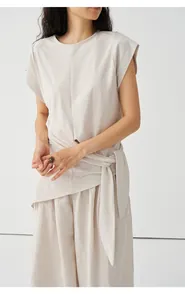 Detailansicht eines minimalistischen beigen Strick-T-Shirts mit Taillenband und Saum.