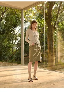 Een volledige outfit met beige gebreid vest met V-hals en olijfgroene midi-rok set