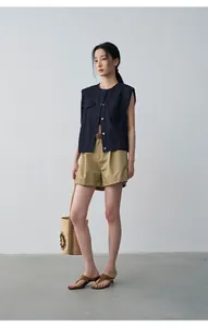 Scatto di una modella che indossa un gilet di jeans blu scuro e pantaloncini kaki