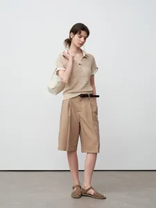 Bermuda kaki minimaliste pour femme porté avec un polo en maille beige
