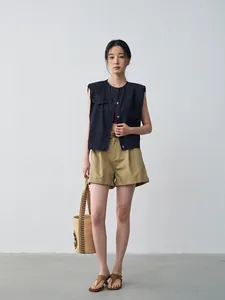 Elegante gilet di jeans scuro senza maniche con scollo rotondo e pantaloncini kaki