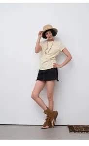 Professional model wearing a slim fit cream T-shirt with necklace and black denim mini skirt
