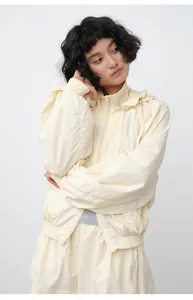 Front view of cream hooded sun protection jacket worn by a model in casual style