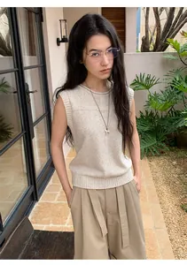 Detailed look of a sleeveless linen-blend knit sweater in oatmeal worn by a female model