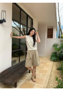 Model wearing a beige sleeveless linen blend knit top and khaki wide-leg shorts outdoors