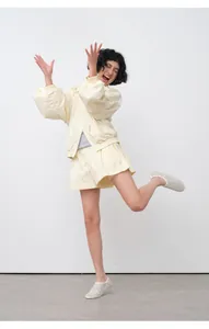 Active pose of a model wearing lightweight cream sun-protection jacket and shorts