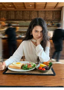 Φωτογραφία lifestyle που δείχνει τη χαλαρή εφαρμογή μιας μπεζ πλεκτής μπλούζας με halter.