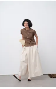Detailed view of women's slim fit brown short sleeve T-shirt styled with wide-leg pants