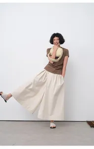 Model wearing a brown slim-fit short-sleeve T-shirt and cream pleated wide-leg pants