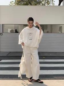 White oversized hooded sweatshirt for women in a minimalist urban outdoor setting