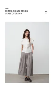 Elegante vrouw met witte blouse met korte mouwen en grijze casual broek met wijde pijpen.