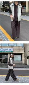 Street style view of a white PU leather vest paired with a brown oversized hoodie set