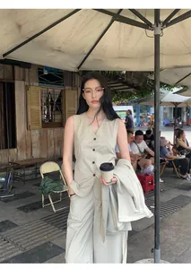 Minimalist beige V-neck sleeveless vest layered with matching wide-leg trousers