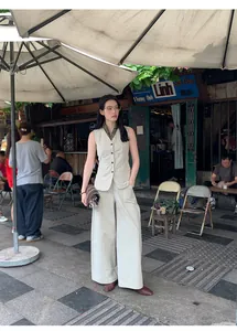 Minimalist beige cotton-blend sleeveless vest paired with wide-leg pants in street setting