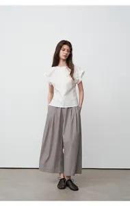 Volledig zicht op een elegante grijze broek met wijde pijpen en een witte blouse met korte mouwen