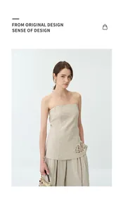 Vue détaillée d'un haut bustier en lin beige avec une broderie ajourée sur l'ourlet