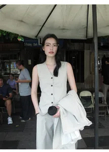 Close-up of a minimalist beige V-neck vest for women worn in a street style setting