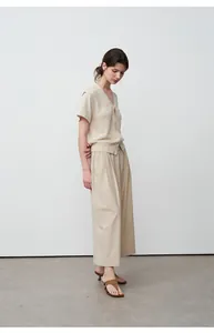 Gedetailleerd overzicht van de beige wijde broek voor een minimalistische casual look