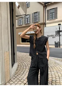 Modèle portant un gilet noir sans manches à double fermeture éclair dans un décor de rue