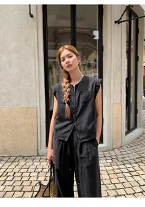 Mannequin portant un gilet noir sans manches à double fermeture et pantalon large