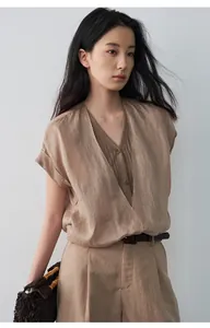 Vue détaillée d'un chemisier en lin col V kaki, design faux deux-pièces sur mannequin.