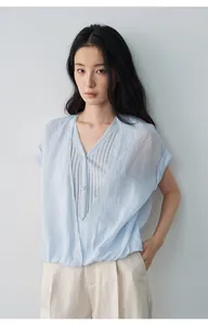Détail d'une chemise bleu clair à col en V avec un design en faux deux-pièces frais