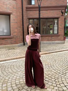 Stilvolles Model trägt farblich abgesetztes Stricktop in Rosa und Burgund mit passender Hose