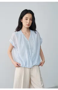 Détail d'une chemise bleu clair à col en V effet deux-pièces avec manches courtes