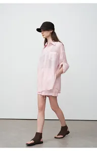 Full view of a woman in a light pink tencel ramie linen shirt and shorts set for summer.