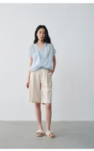 Vue détaillée d'un haut bleu clair à col en V effet deux-pièces avec un short beige
