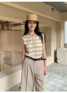 Λεπτομέρεια γυναίκας που φοράει ριγέ αμάνικο πλεκτό τοπ με ψάθινο καπέλο για το καλοκαίρι.