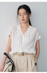 Vue détaillée d'une chemise blanche à col en V effet deux-en-un sur un mannequin.