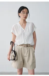 Mannequin asiatique portant une chemise blanche à col en V et un short beige.