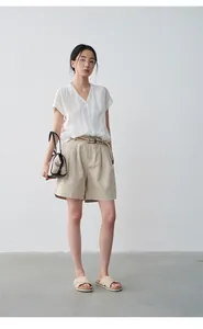Mannequin asiatique portant une chemise blanche à col en V et un short en lin beige
