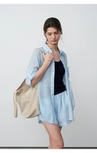 Detail of a woman wearing a light blue tencel ramie lazy style shirt with matching shorts