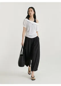 Asian model showcases white off-shoulder layered T-shirt with black wide-leg trousers