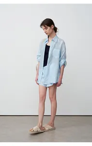 Woman wearing light blue tencel ramie oversized shirt and matching shorts for summer.