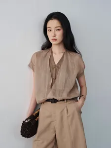 Modèle portant une chemise marron col V effet deux-pièces et un pantalon assorti