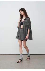 Full body shot of a minimalist grey Tencel ramie oversized shirt and shorts set.