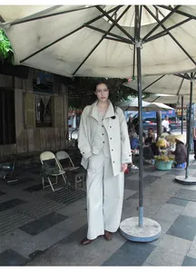 Elegant lifestyle shot featuring a minimalist light beige V-neck vest in cotton blend