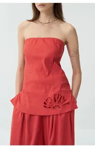 Détail d'un haut rouge sans bretelles en lin avec des motifs de broderie ajourés complexes